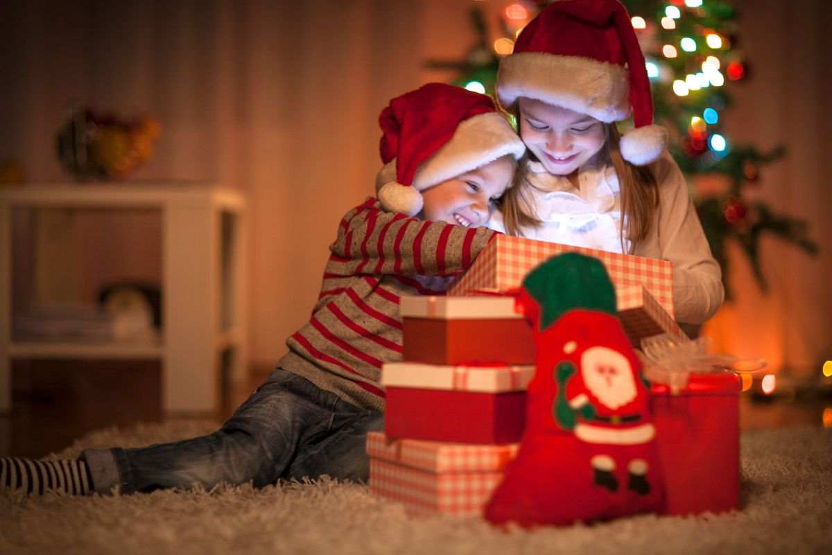 Due bambini scartano i regali di Natale